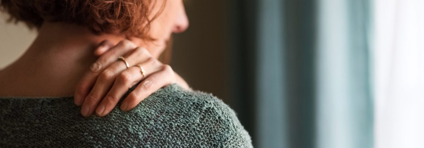 Rear view shot of a woman suffering from a shoulder pain